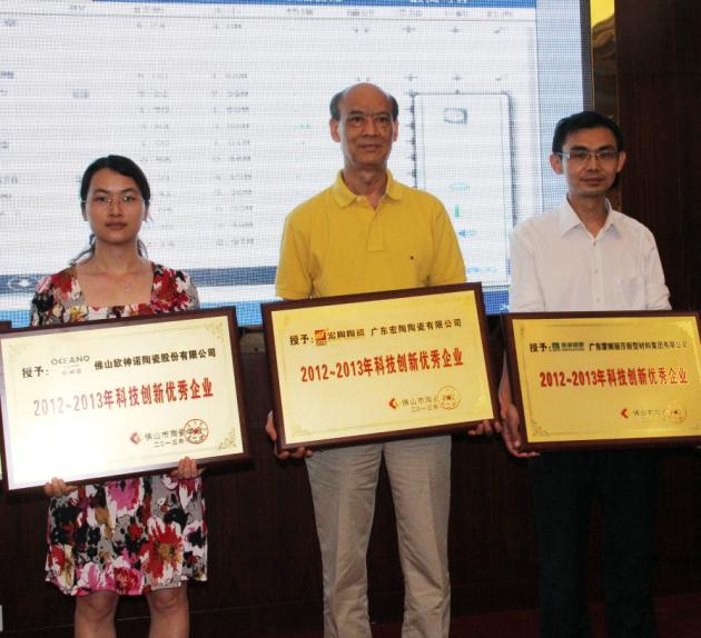图4、广东腾博会官网陶瓷有限公司被授予“2012—2013年佛山陶瓷科技立异优异企业”称呼，，，，，，，该企业副总司理欧家瑞（中）接受颁奖.jpg