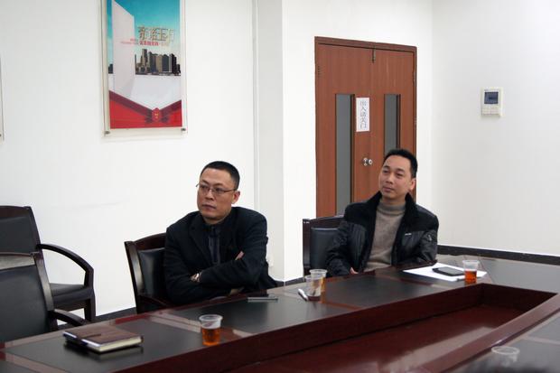 图5、腾博会官网抛光砖销售副总张彦（左一）、腾博会官网广东线销售副总庞永江（右一）认真寓目参评专卖店幻灯片播放效果